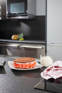 Chocolate topped strawberry cake in a kitchen.