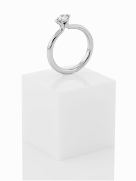Wedding rings on top of white pedestal.