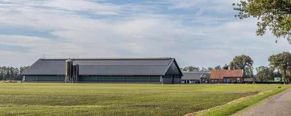 Old farmhouse with large modern stables with solar panels at the countryside of Drenthe The Netherlands