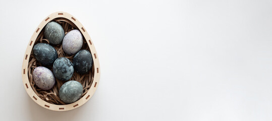 Different easter eggs in wood egg shape box on white background