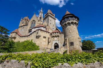 Ancient castles architecture in Europe. Austria medieval citadel made of bricks. Rocky walls of an old historical castle with towers and bridge on a sunny summer day, European landmark and history