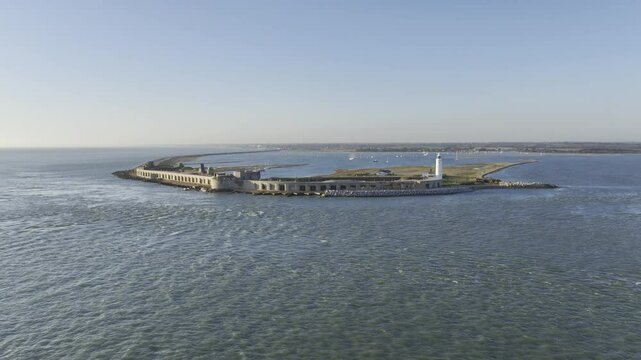 Hurst Point Lighthouse and Hurst Castle on the seaward end of a coastal spit in Hampshire, England (Aerial 4K HDR ProRes drone footage)