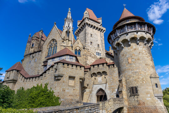 Ancient castles architecture in Europe. Austria medieval citadel made of bricks. Rocky walls of an old historical castle with towers and bridge on a sunny summer day, European landmark and history