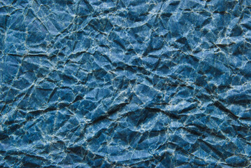 A sheet of old wrinkled glossy blue paper texture as background