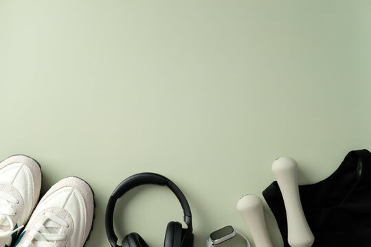 Feminine fitness workout essentials and sportswear on pastel green background.