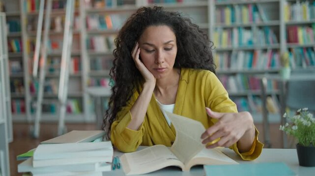 Tired Caucasian Latina woman student reading book textbook preparing difficult exam bored library studying girl university female read sad learning turn page exhausted high school education session