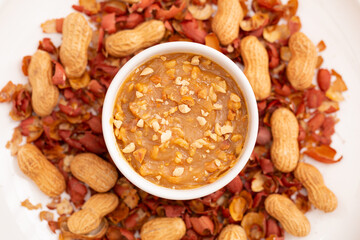 Peanut butter seen from above, on a plate decorated with a wooden background.
