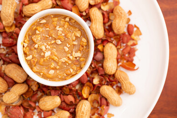 Peanut butter seen from above, on a plate decorated with a wooden background.