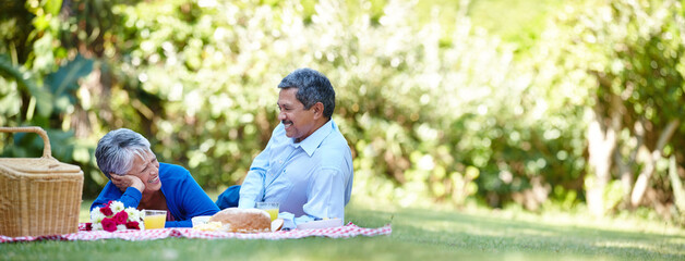 Calm, smile and picnic with old couple in nature for peace, happiness and anniversary date. Health, trust and bonding with senior man and woman in park for food, relax or retirement banner together