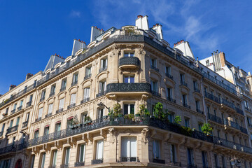Obraz premium Exterior architecture of Traditional French house with typical balconies and windows in Paris. Traditional Parisian street light in the foreground.