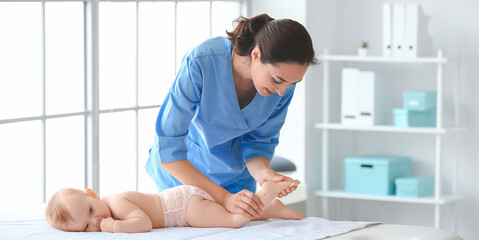 Massage therapist working with cute baby in medical center