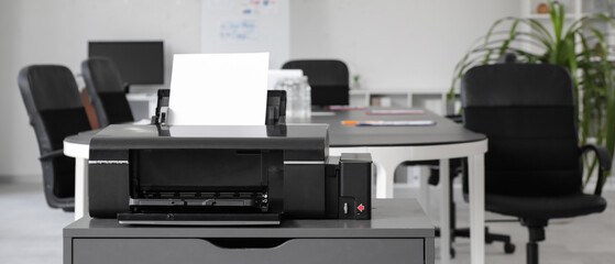 Modern printer on chest of drawers in stylish office