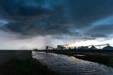 Lightning strikes near potash mine during stormy sunset