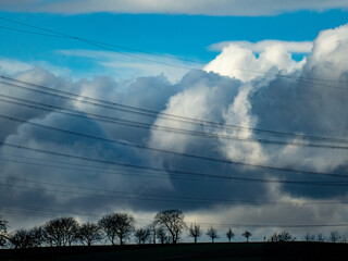 Strommasten unter dunklem Wolkenhimmel