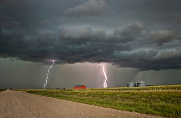 Lightning strikes illuminate a rural landscape during a dramatic storm