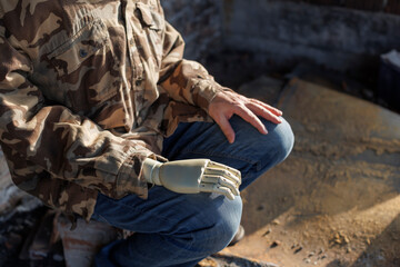 Military veteran with prosthetic hand sitting in ruined room