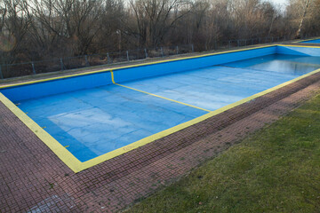 Abandoned outdoor swimming pool in winter