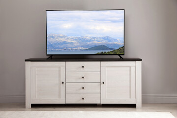 Fototapeta premium TV set with mountain landscape on screen in room