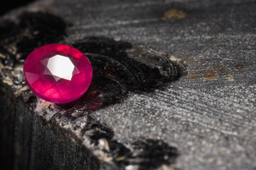 Beautiful shiny pink gemstone on stone, space for text