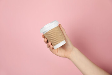 Woman holding paper cup on pink background, closeup. Mockup for design