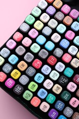 Many colorful markers in bag on pink background, top view