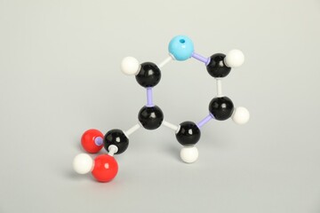 Molecule of niacin (vitamin B3) on light grey background. Chemical model