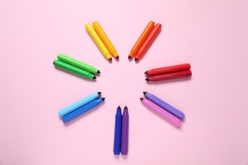 Many colorful markers on pink background, flat lay