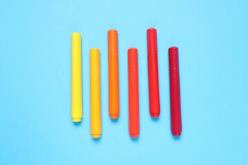 Many colorful markers on light blue background, flat lay