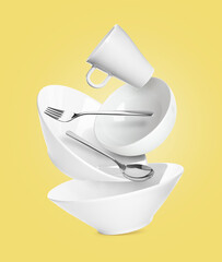 Clean dishware and silverware flying on pastel yellow background