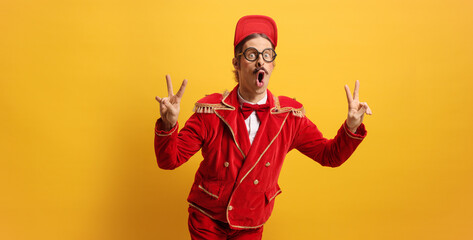 Entertainer in a red suit gesturing peace sign