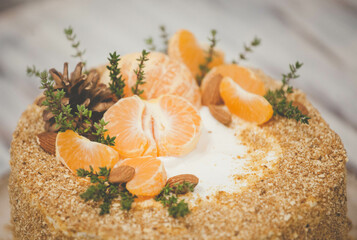 Honey cake with buttercream on a wooden background with winter decor