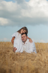 dad and daughter hug in a wheat field.Cute beautiful children.Family vacation.Happy family resting in summer park.Cheerful family picnicking in the park.Summertime and vacation concept.
