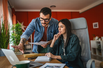 Obraz premium two colleagues work from home on laptop and clipboard on new project