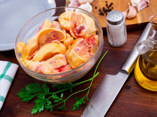 Raw chicken with condiments on kitchen table. Still life of uncooked food.
