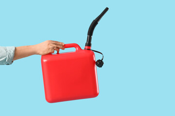 Male mechanic holding canister on blue background