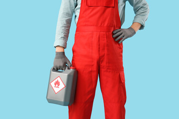 Male mechanic with canister on blue background