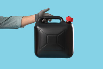 Male mechanic holding canister on blue background
