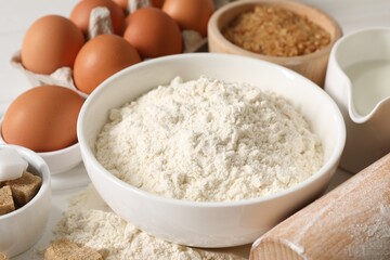 Ingredients for dough and rolling pin on table, closeup
