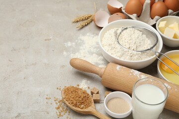 Rolling pin and different ingredients on light table. Space for text