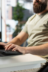 Data scientist typing on keyboard, doing software quality assurance, writing source code on computer. Close up of man in office inspecting coding on PC device, looking to fix potential issues