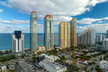 Obraz premium Sunny Isles Beach city with luxurious highrise hotels and condo buildings on Atlantic ocean shore. American tourism infrastructure in southern Florida