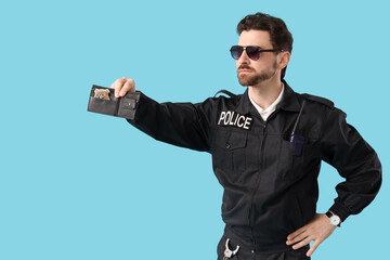 Male police officer showing badge on blue background