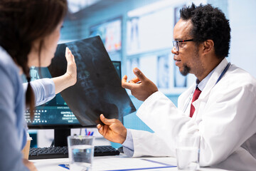 African american physician presenting the x ray diagnostics results to a patient, examining the...