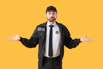Thoughtful male police officer on yellow background