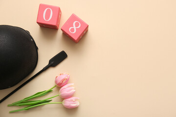 Horse riding helmet with crop, cube calendar and tulip flowers on beige background. International Women's Day celebration