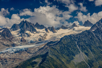 Alps scenic landscape on Tour du Montblanc. Rocky and snow summit peaks of the Alps on the trekking route TMB around Mont Blanc in Chamonix and Courmayeur. Alpine scene with mountains and lakes