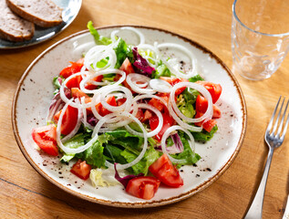 Delicious fresh vegetable salad with tomato and onion served on plate