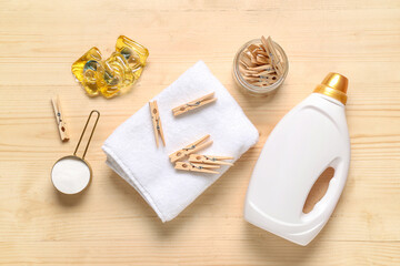 Jar of clothespins with laundry detergents and towel on brown wooden background