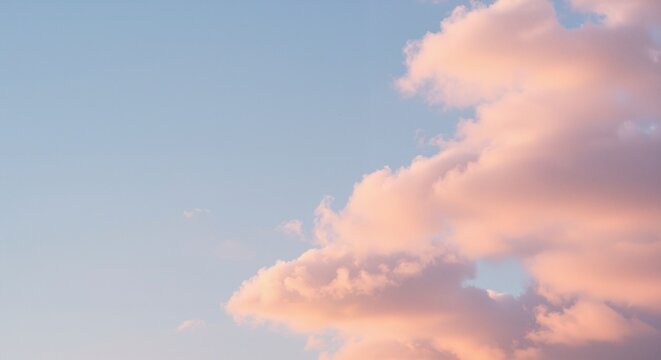 Soft pastel clouds against a serene blue sky create a peaceful atmosphere, evoking tranquility and calmness in the early evening light