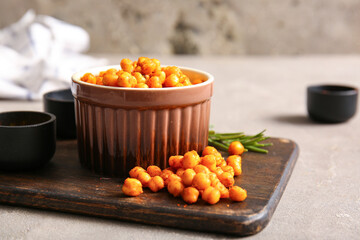 Bowl with tasty fried chickpeas and rosemary on grey background